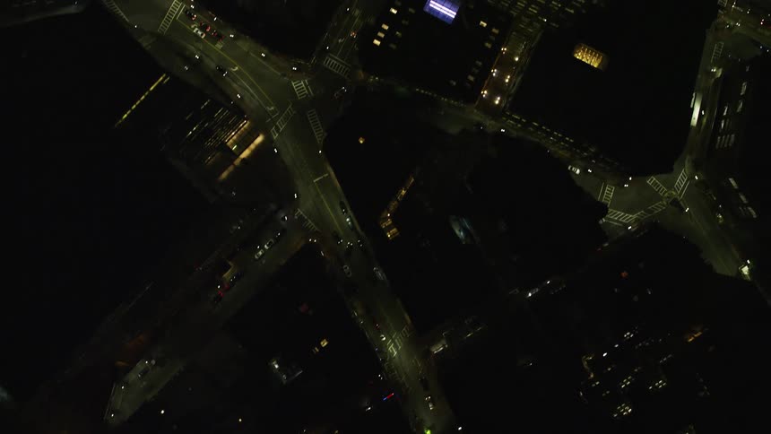 Aerial view of a downtown area buildings and streets during a night flight