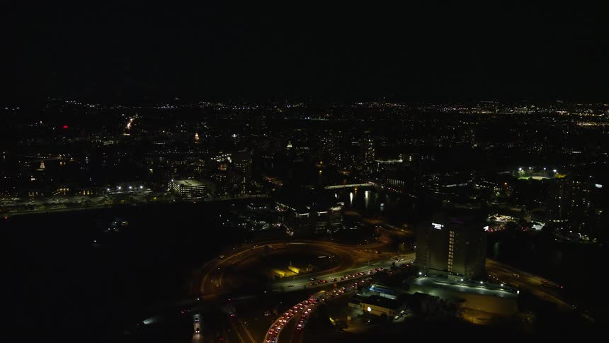 The city is dark at night as traffic runs through