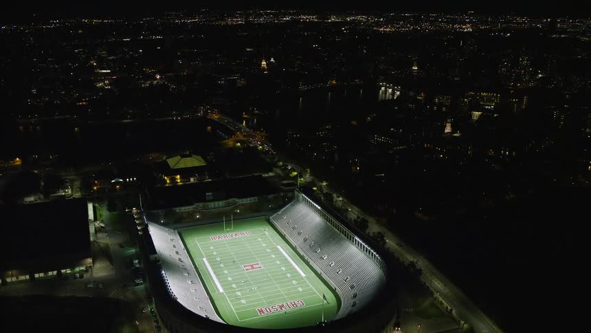Aerial of buildings stadium and moving cars in a metropolitan area at night