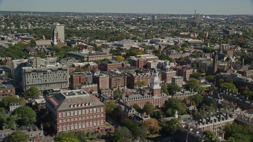 A daytime aerial view of a river bridge and block in a large city