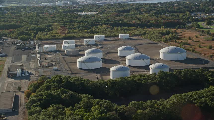 Several round industrial buildings isolated in a field with many trees