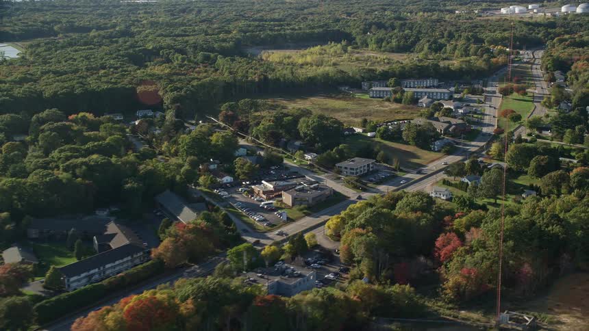 Aerial view of cars driving on a road through a small town
