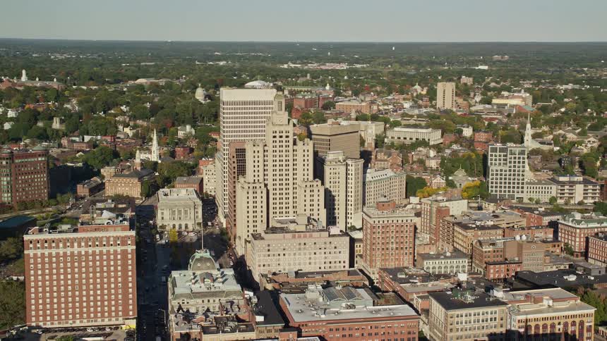 An aerial view of a downtown tower block surrounded by trees