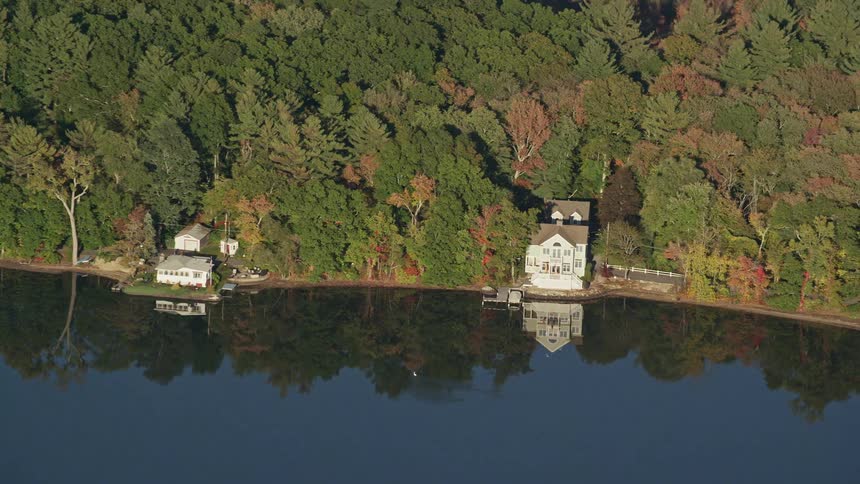 Panorama of two houses amidst a forest by the lakeside
