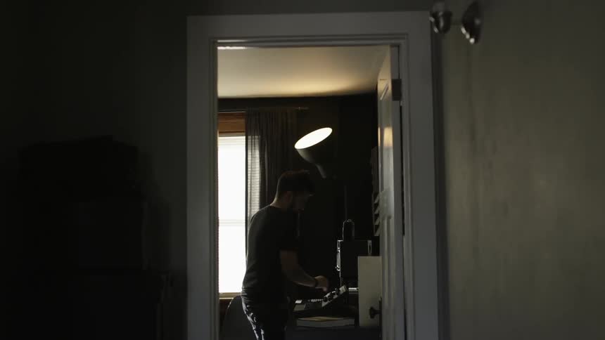 A man is using musical instruments in the room ahead