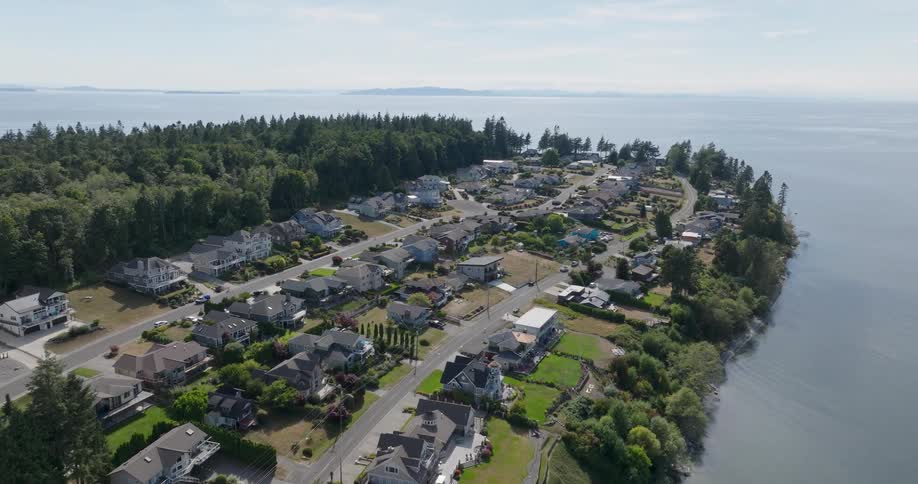 Waterfront homes line the ridge of a coastal neighborhood surrounded by ocean