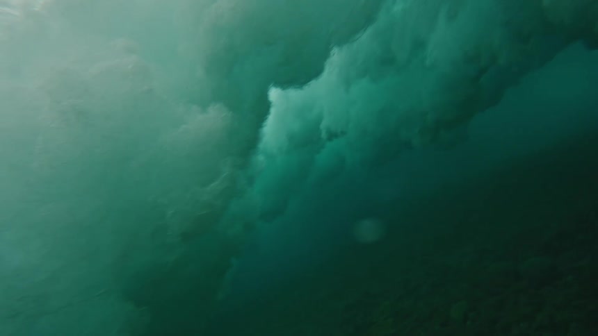 Murky water near seafloor churns as waves crash above
