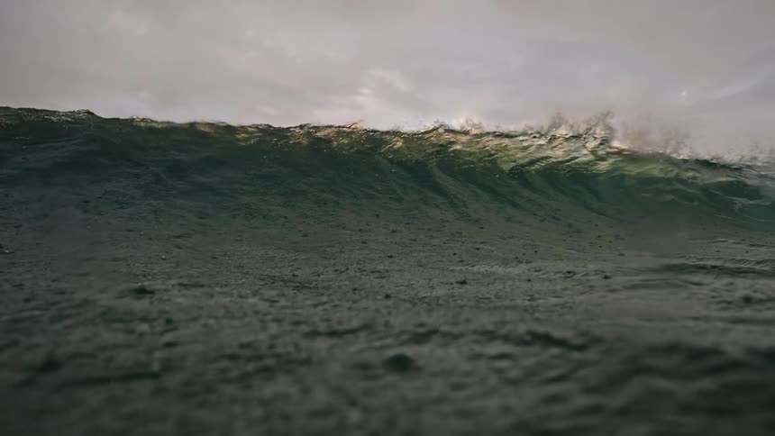 Green ocean wave passing overhead