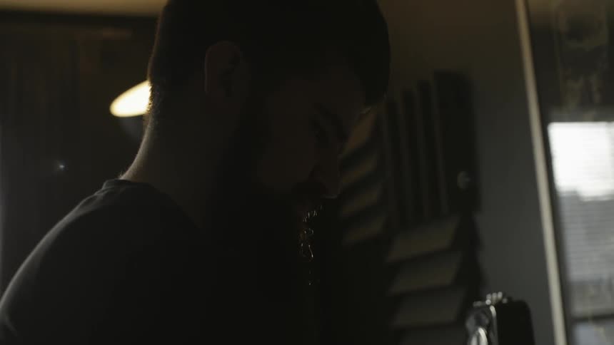 A man is looking turning knobs on a keyboard