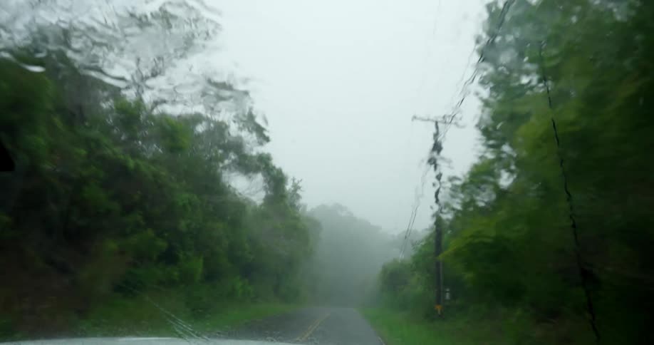 A car is driving through a rain storm