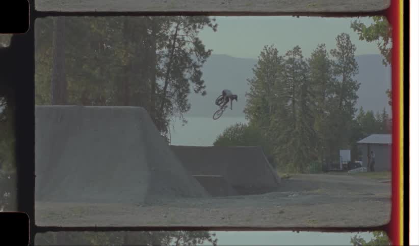 Two people are jumping ramps on their bicycles