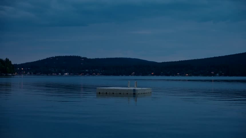 A white platform in the middle of the water at night