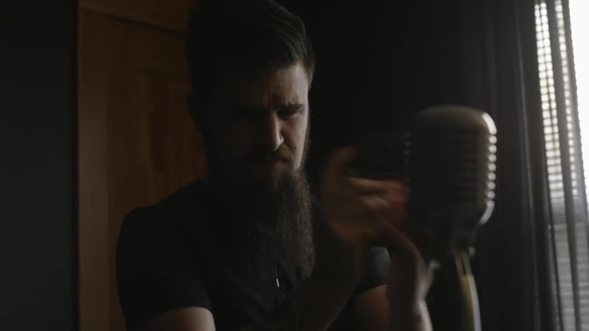 A man is shaking something in front of a microphone
