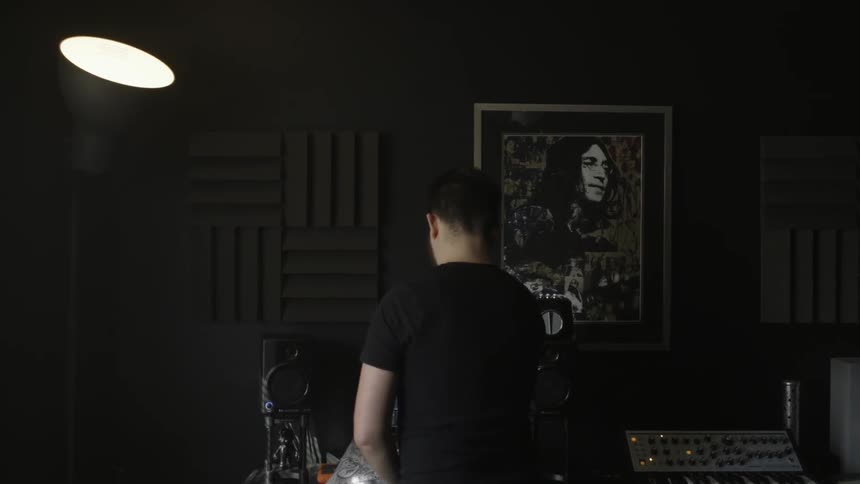 A man is operating some musical equipment in a studio