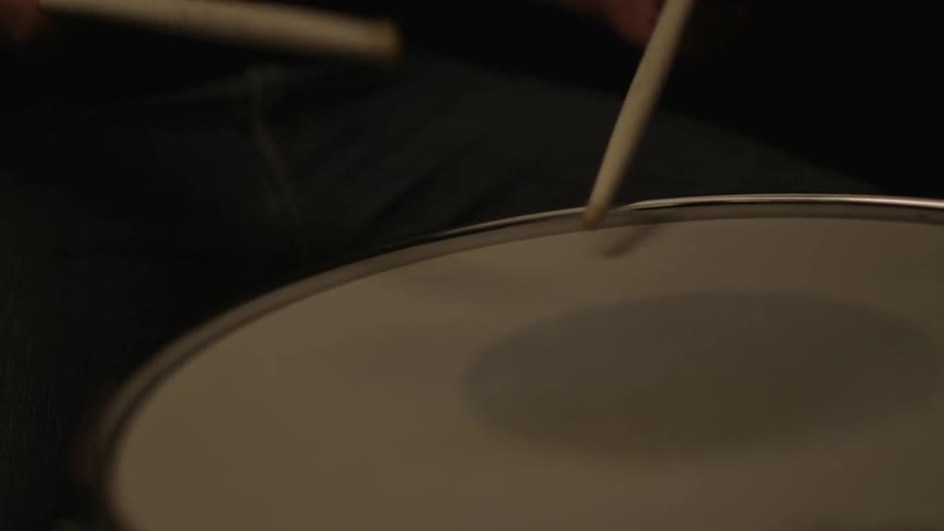 Two sticks are beating on a drum