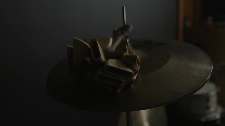 A drum cymbal sits in a dark room