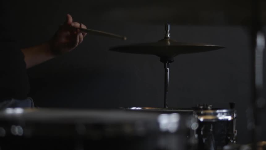 A man is tapping drums with a stick