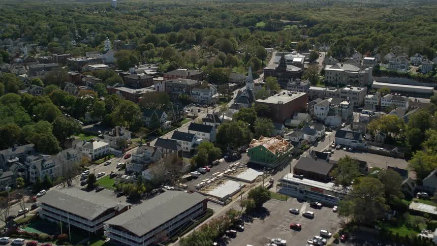 Aerial view of a coastal suburb houses a churches and the downtown area