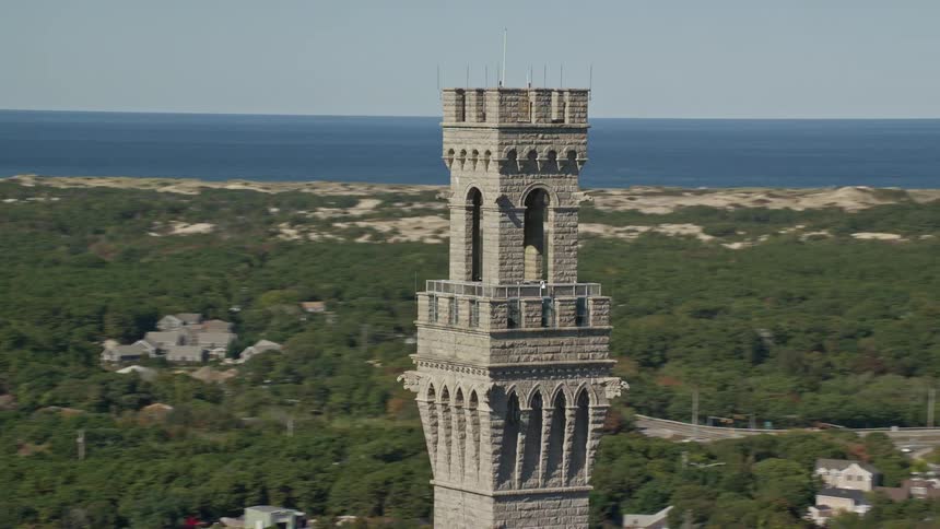 A watchtower overlooking a suburban town a large woodland area and the sea