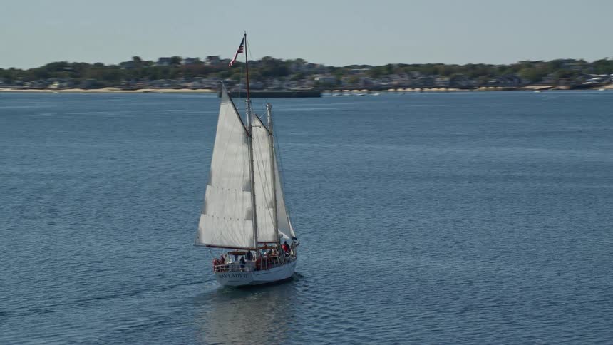 A sailboat sailing towards a beach