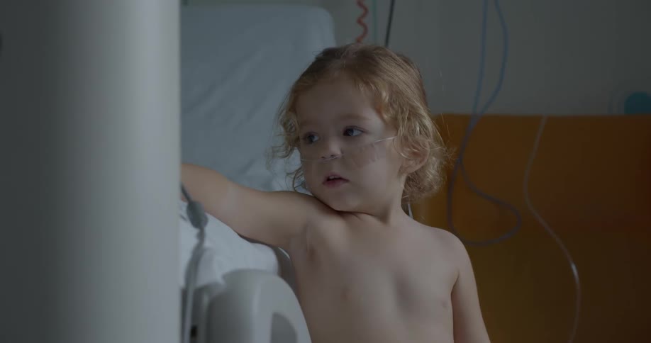 A child is reaching to the bed