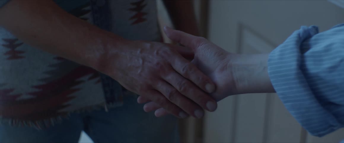 Someone extends a hand to an older person who takes it