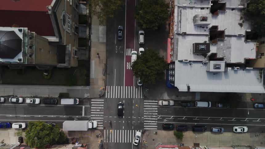A moving car on a city street at midday