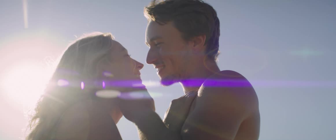A man and a woman in their swimsuit being all loving and romantic in a sunny day