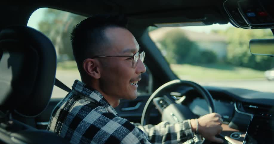 A man is talking with someone as he drives