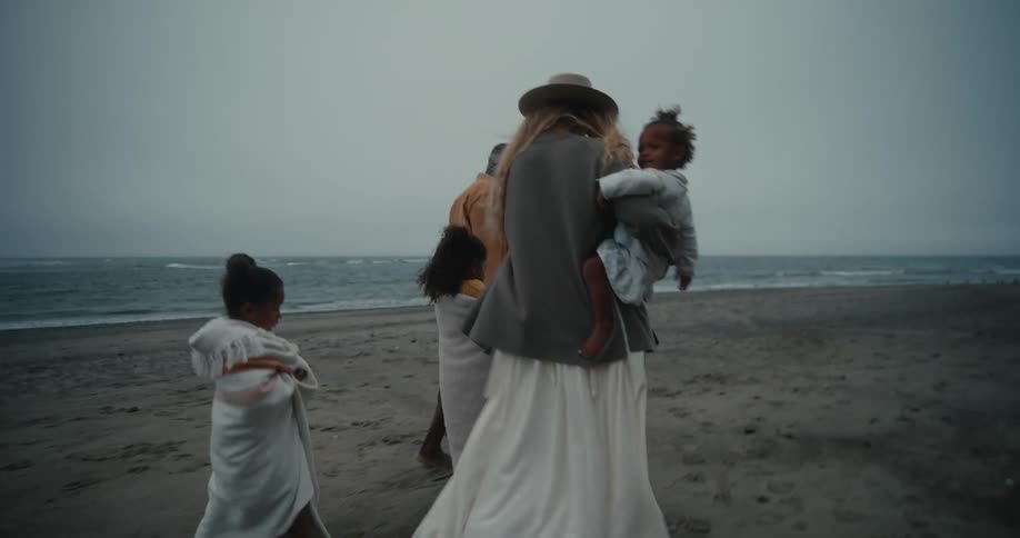 A family walking on the beach on a cloudy day