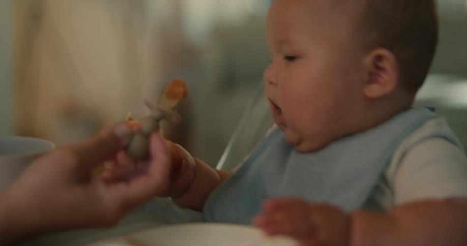 A mother feeding her baby while sitting in a car seat
