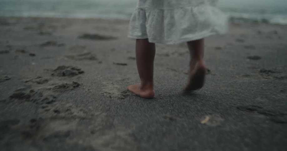 Closeup of a childs feet walking on the beach sand