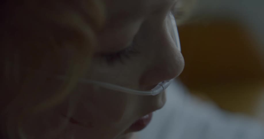 A young girl with a breathing tube in her nose