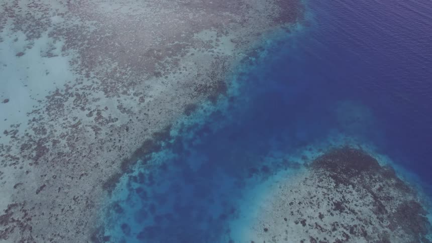 A small island with just sand in the middle of the ocean