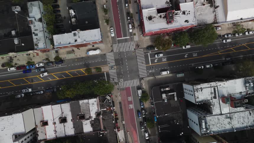 Cars drive by in an intersection in a residential area