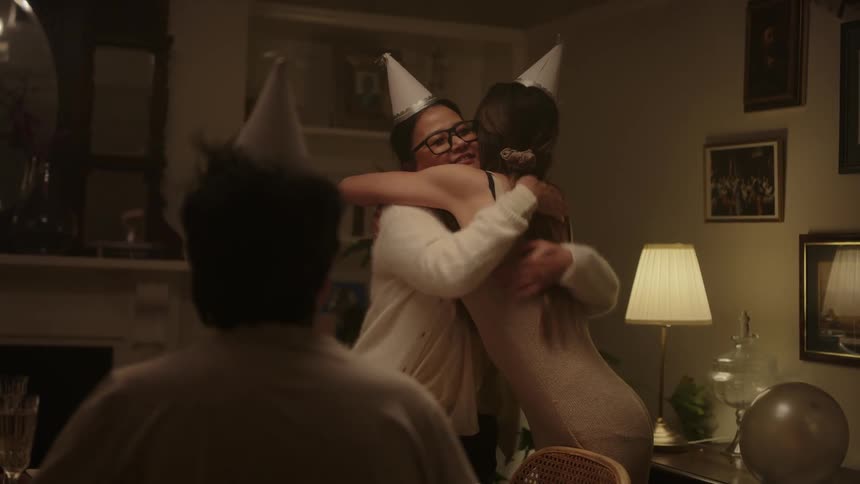 Happy womans receives a gift for her birthday at the dinning table