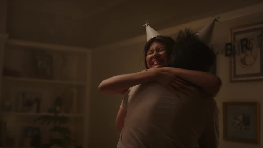 Friends at a birthday party get up and hug