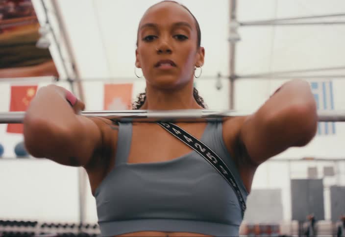 A woman is lifting weights in the gym