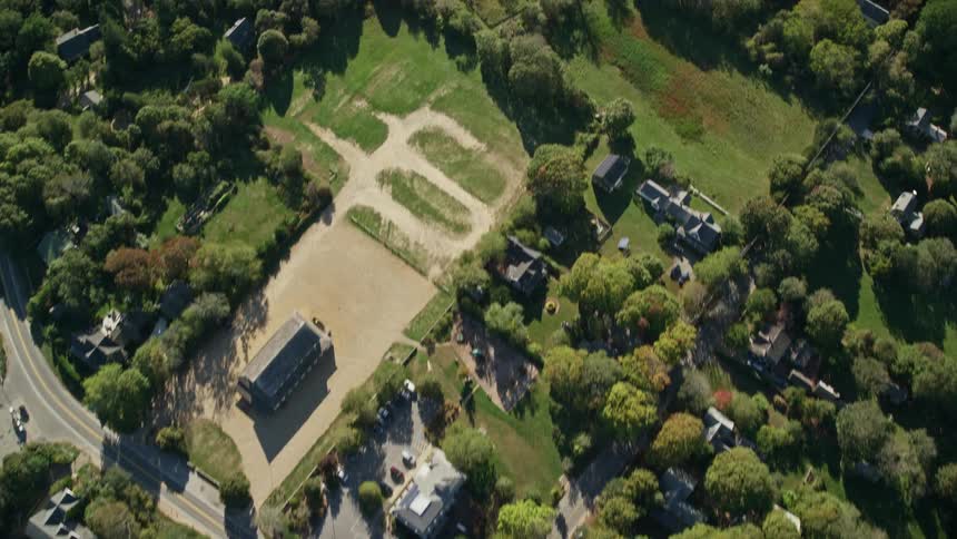 Aerial view of a road and buildings surrounded by green trees