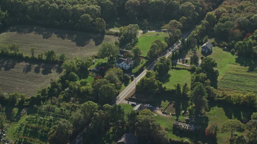 A rural region with a small farm and several trees