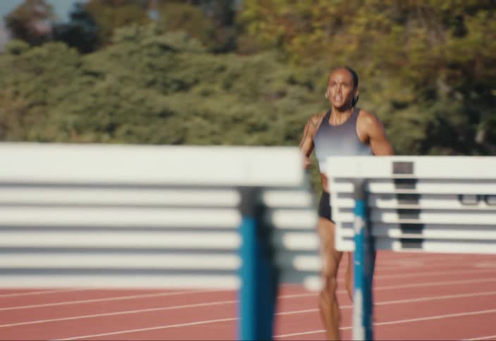 Woman trains on running track near mountains