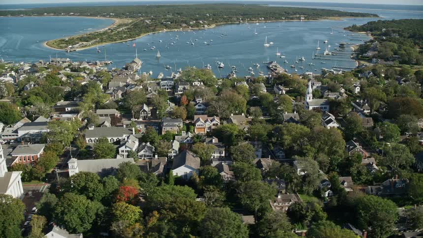 Several boats float near coast in bay of coastal town