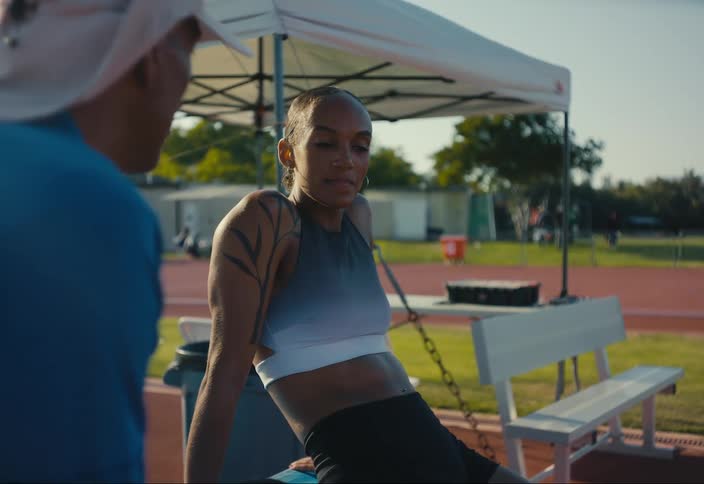 Young athlete track talks to her coach after a race