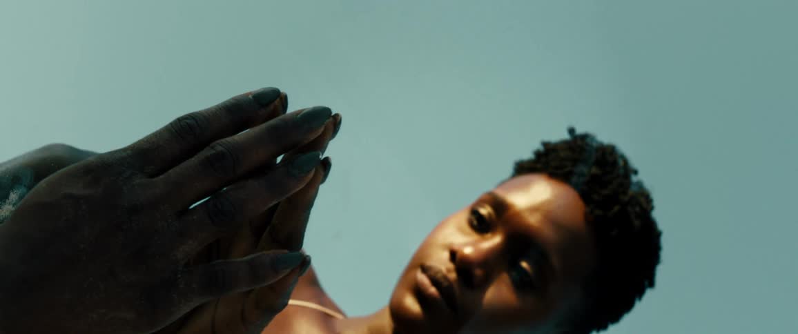 A lady rub fingers on a mirror while looking sad