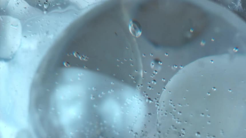 Bubbles float through water with ice cubes