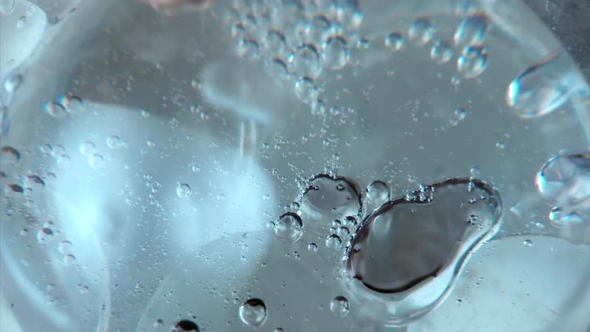 Bubbles stretch and move as they float inside a clear sphere