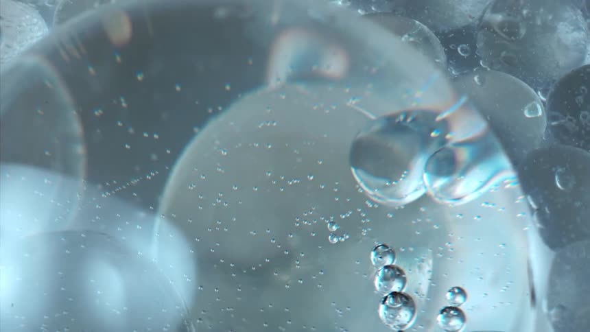 Ice floats through water disturbing bubbles