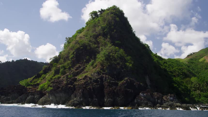 Bushes cover the rocks that rise above the water