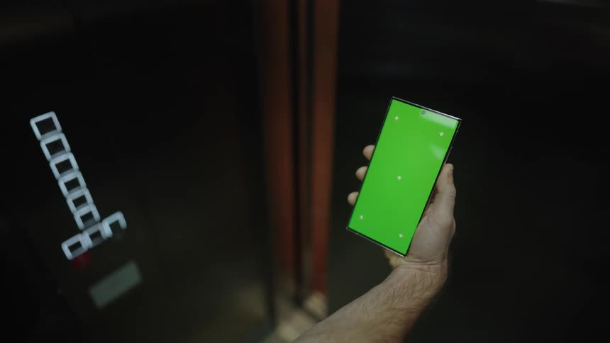 Man uses elevator while holding smartphone