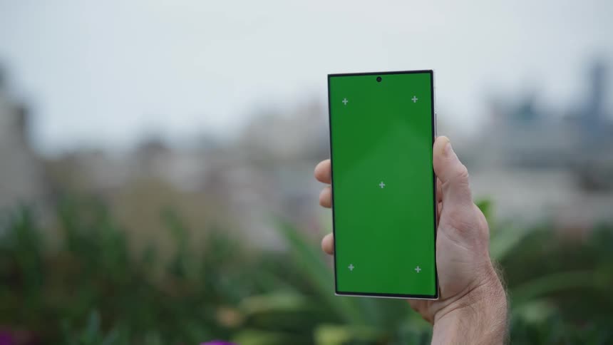 A man holds up a smart phone with a larger than average screen